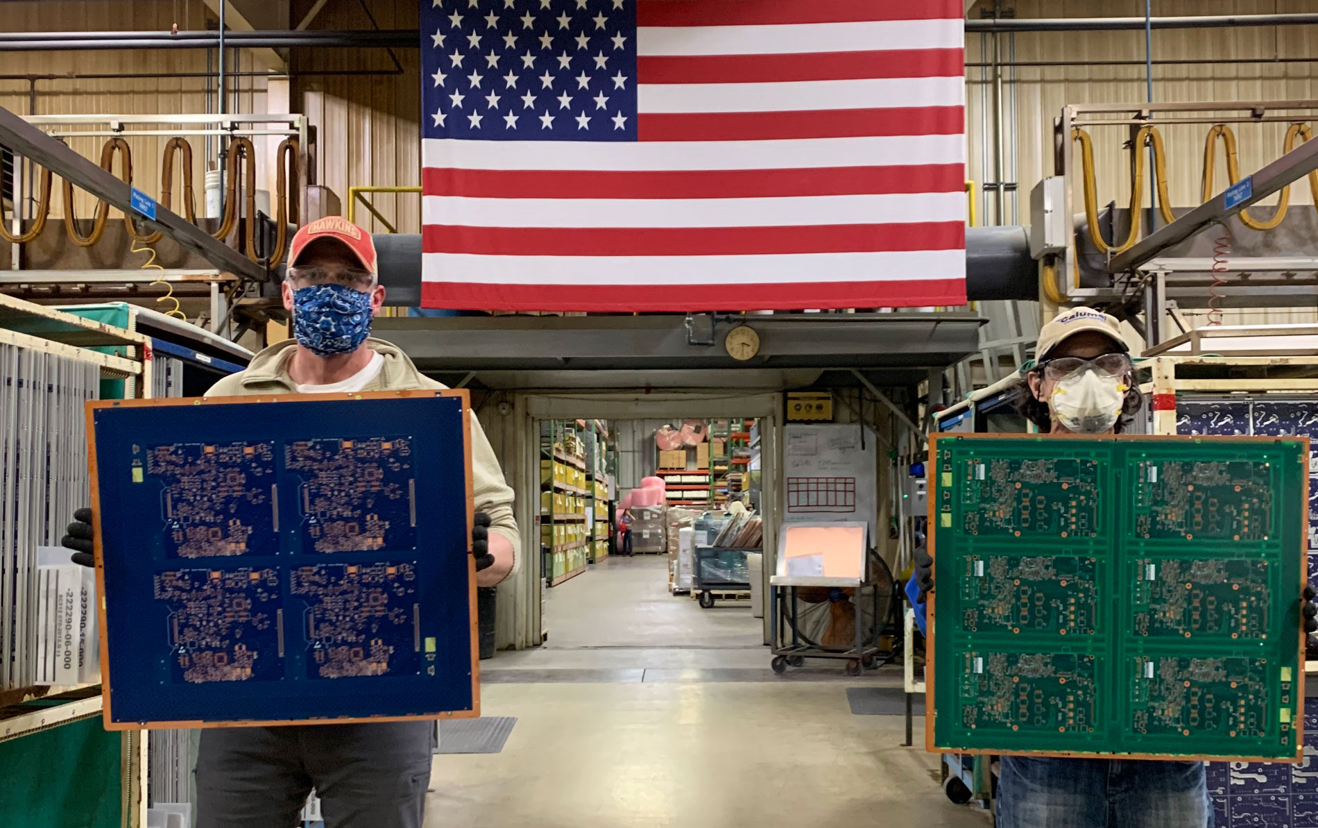 Calumet Electronics employees holding circuit boards created for breathing machines that help fight COVID-19